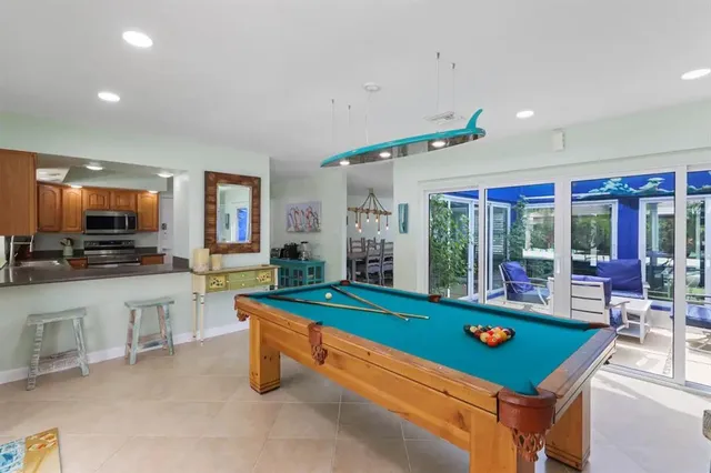 a room with pool table and windows