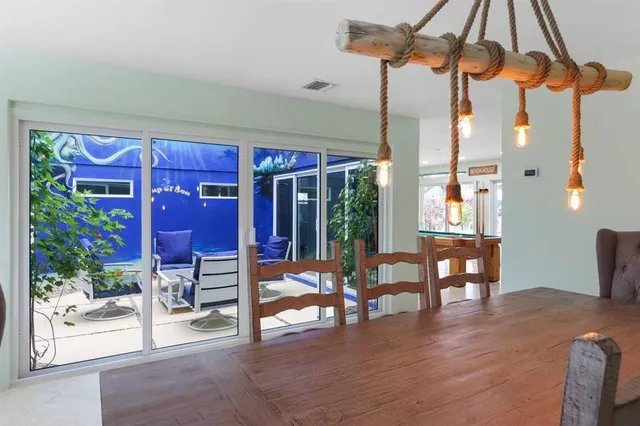 a dining room with furniture a chandelier and wooden floor