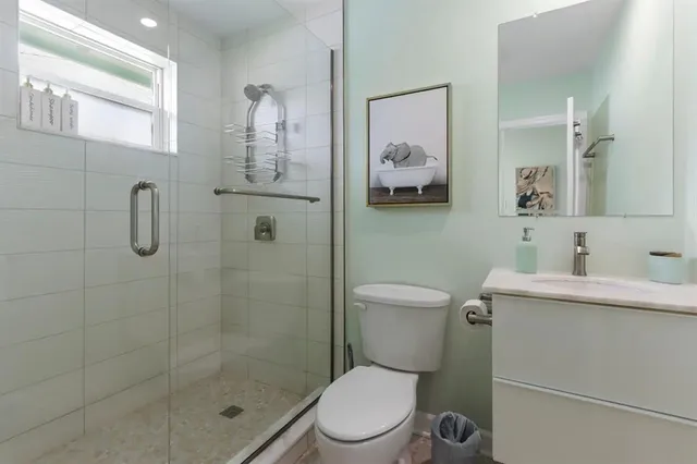 a bathroom with a toilet sink vanity and mirror