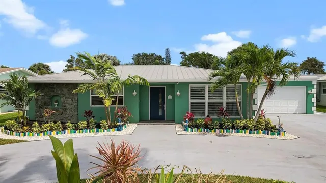 a front view of a house with a yard and potted plants