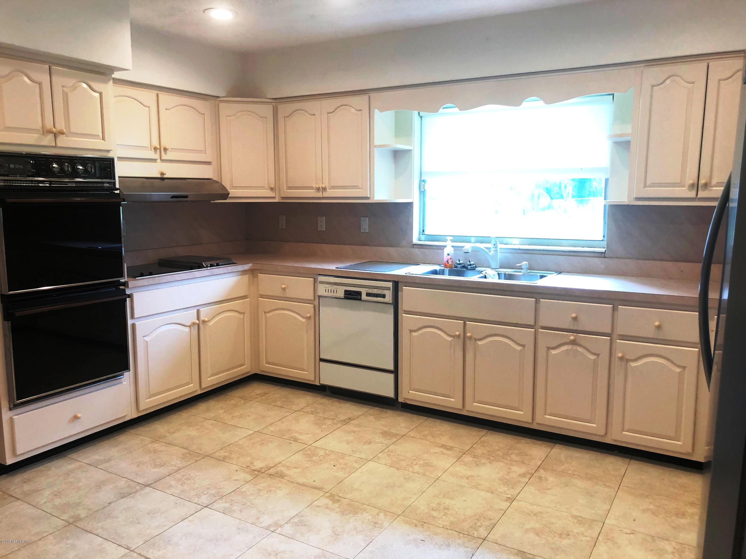 730 North Park Street Crescent City, FL 32112 - Photo 14 of 31 a kitchen with granite countertop cabinets stainless steel appliances a sink and a window