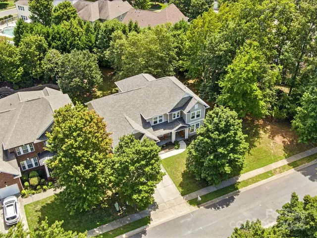an aerial view of a house with a yard potted plants and large tree