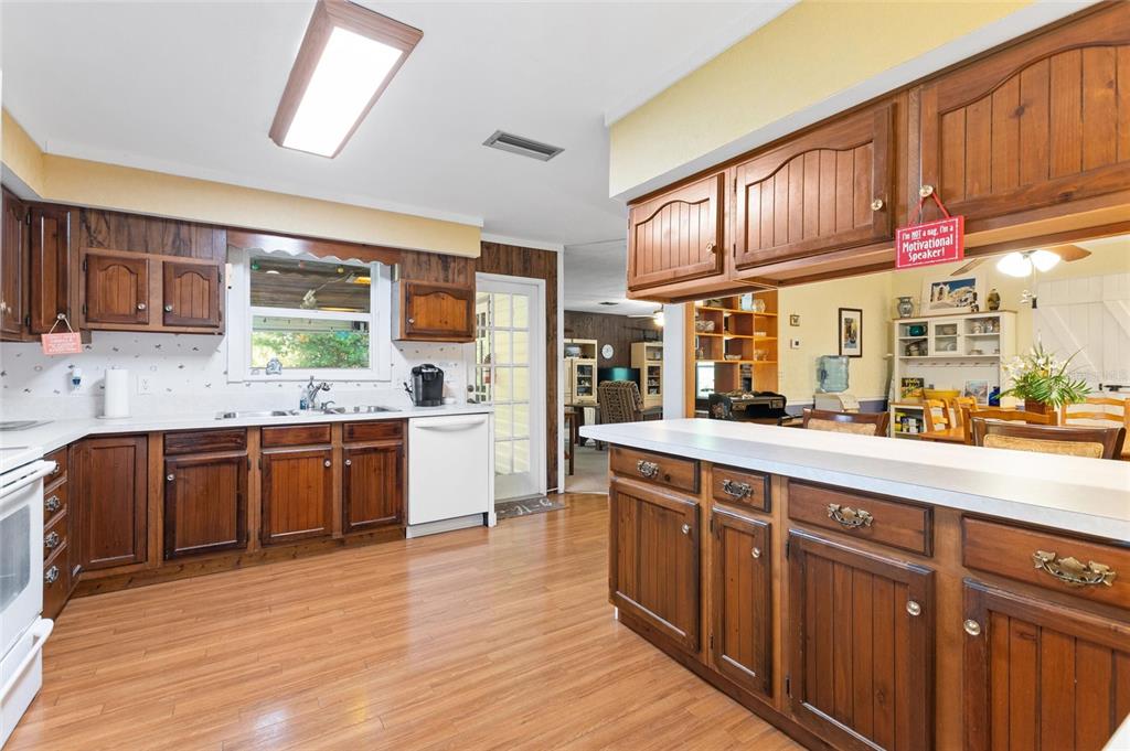 3641 Turtle Mound Road Melbourne, FL 32934 - Photo 9 of 77 a large kitchen with stainless steel appliances wooden cabinets a center island and a window
