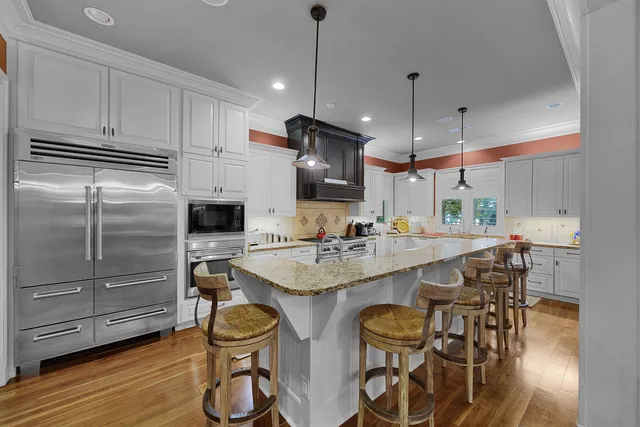 a large kitchen with kitchen island a large counter space a sink appliances and cabinets