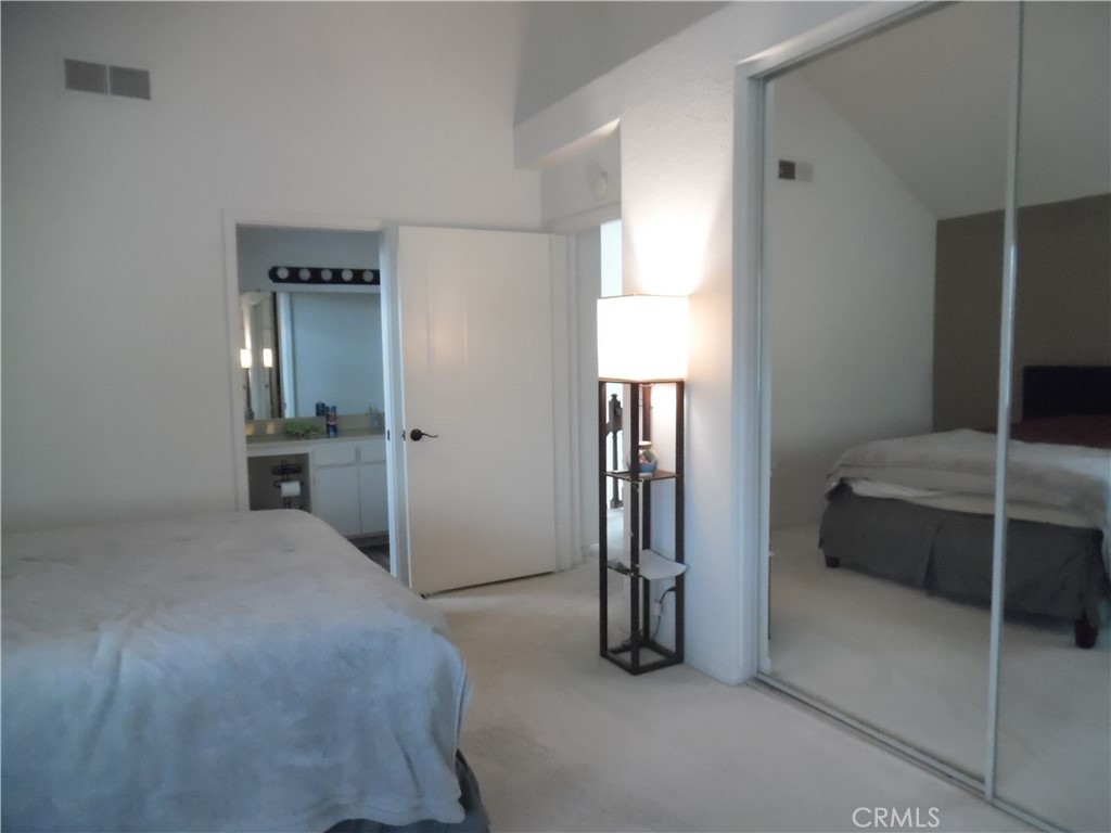 1806 Rory Lane, Unit 9 Simi Valley, CA 93063 - Photo 19 of 28 a bedroom with a bed and a lamp on closet