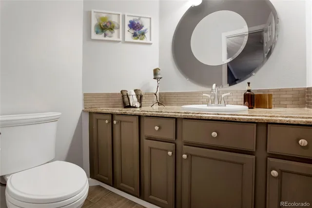a bathroom with a granite countertop toilet sink and mirror