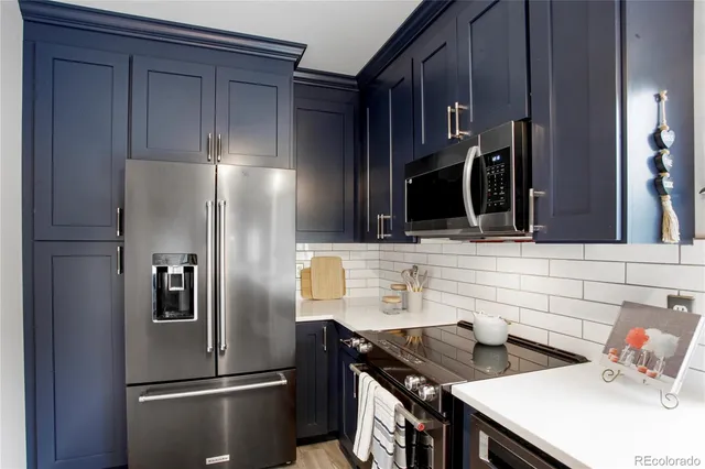 a kitchen with stainless steel appliances kitchen island a refrigerator and a sink