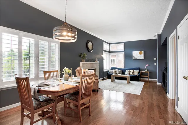 a view of a dining room with furniture a chandelier and wooden floor