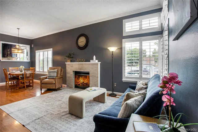 a living room with furniture fireplace and a large window