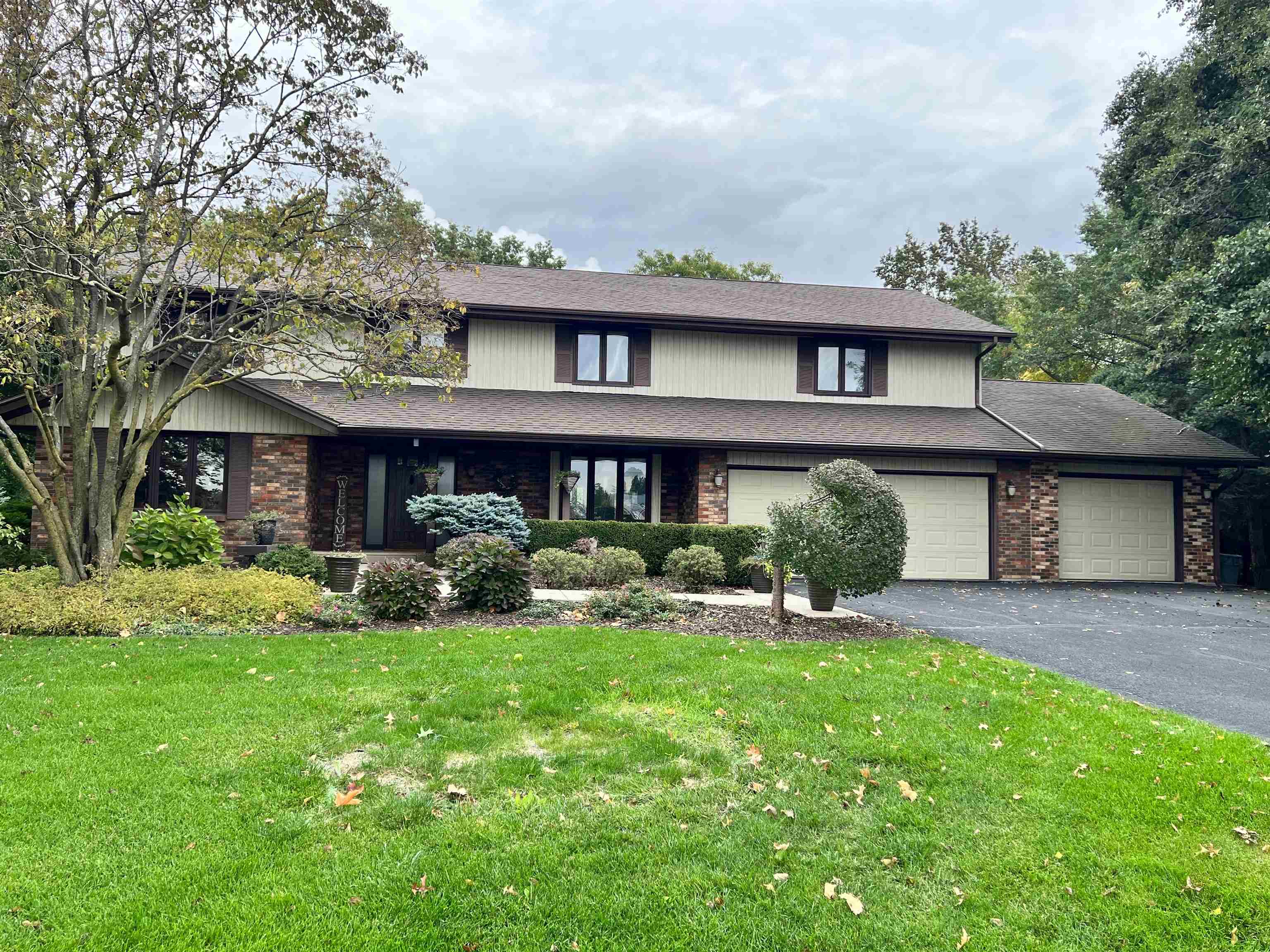 a view of a brick house with a yard and plants
