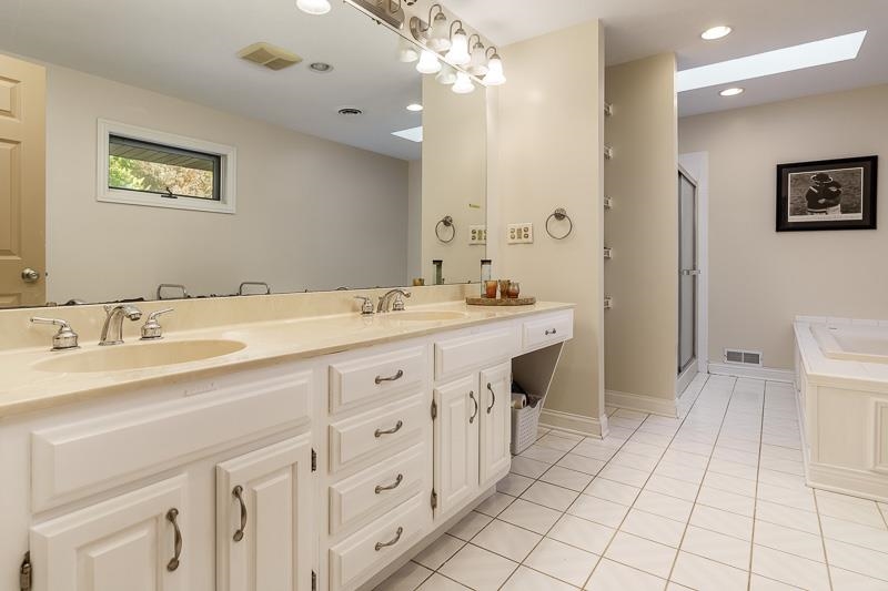 1753 Madron Road Rockford, IL 61107 - Photo 21 of 46 a spacious bathroom with a granite countertop sink a toilet a mirror and vanity