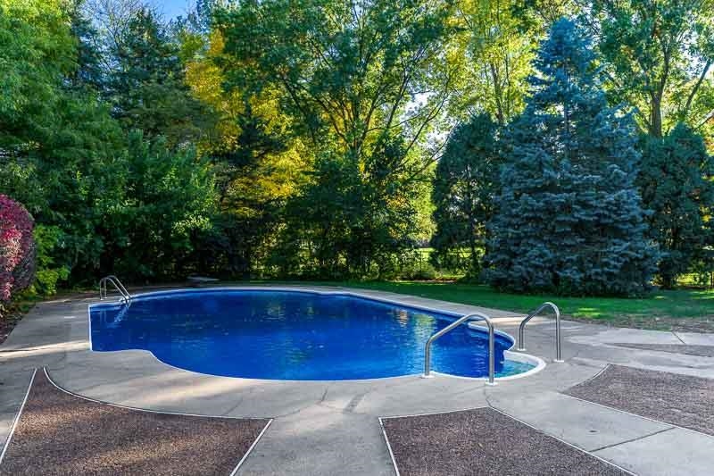 1753 Madron Road Rockford, IL 61107 - Photo 35 of 46 a view of swimming pool with lawn chairs plants and large trees