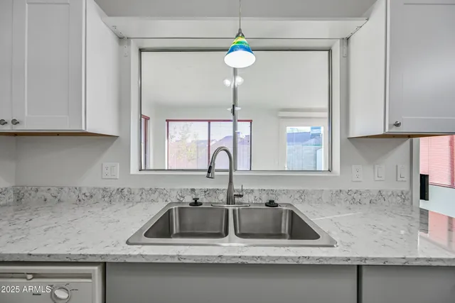 a kitchen with sink a window and cabinets