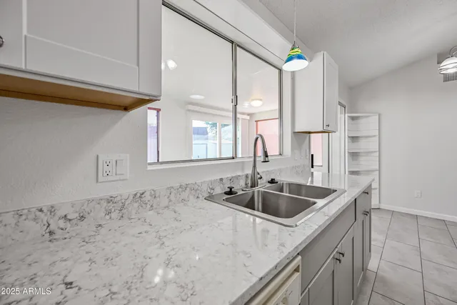 a kitchen with granite countertop a sink and a refrigerator