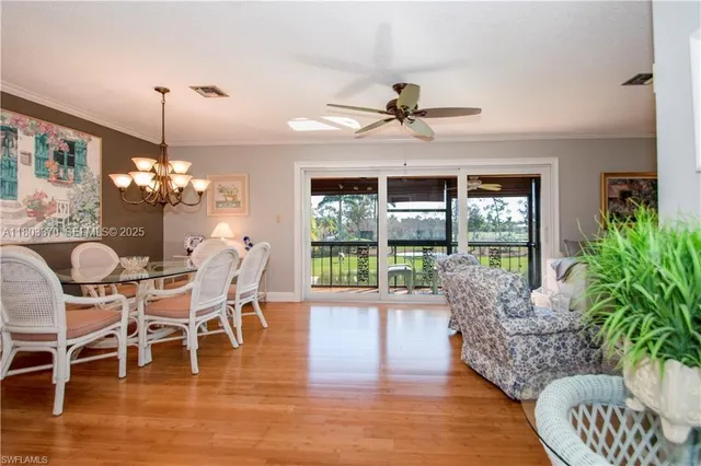 a dining room with furniture a chandelier and wooden floor