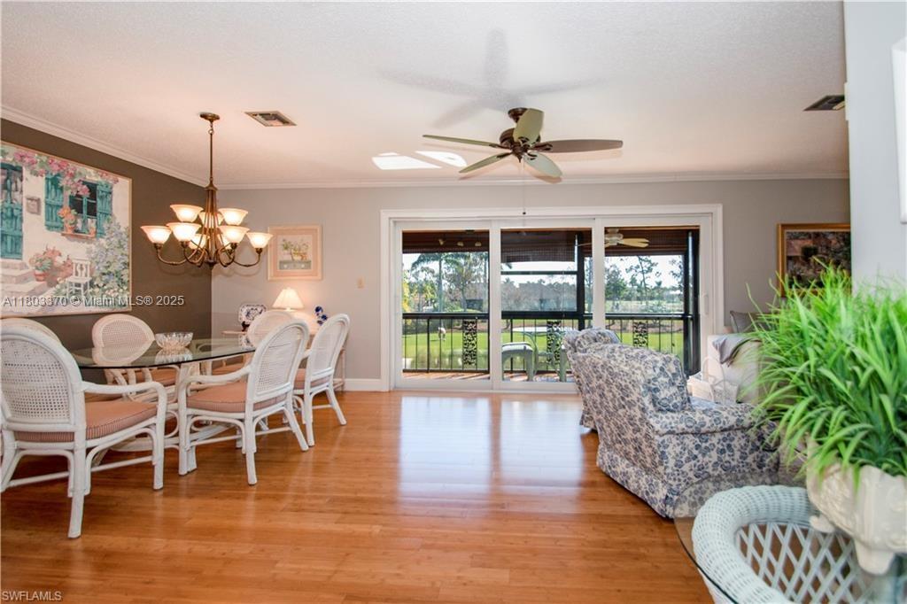 162 Teryl Road, Unit 62 Naples, FL 34112 - Photo 4 of 13 a dining room with furniture a chandelier and wooden floor