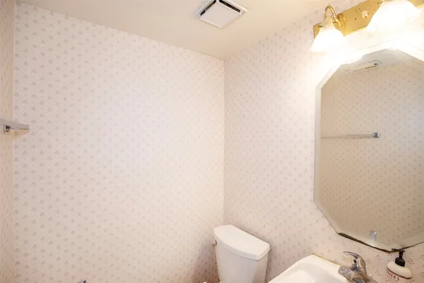 a white toilet sitting next to a white wall