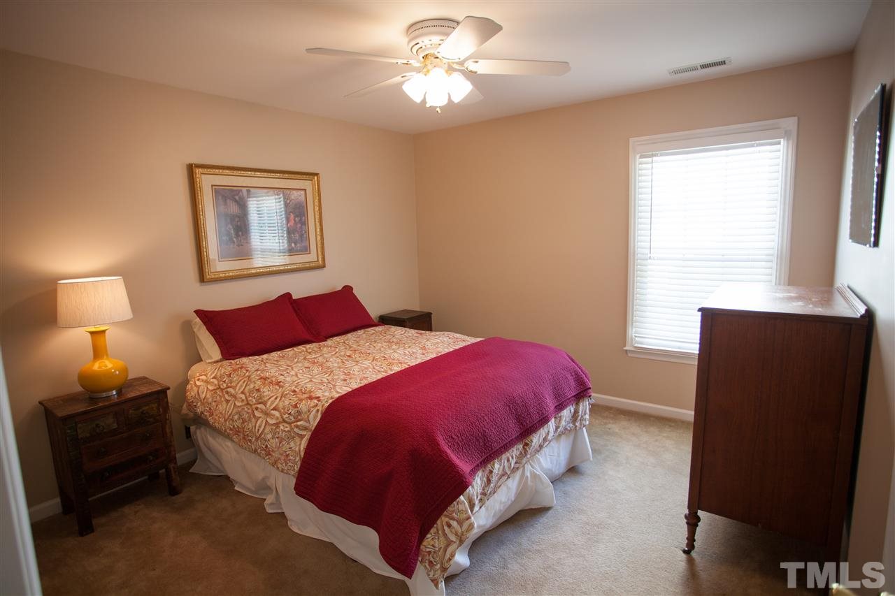 8820 Braceridge Road Raleigh, NC 27613 - Photo 16 of 22 a bedroom with a bed and a lamp with window