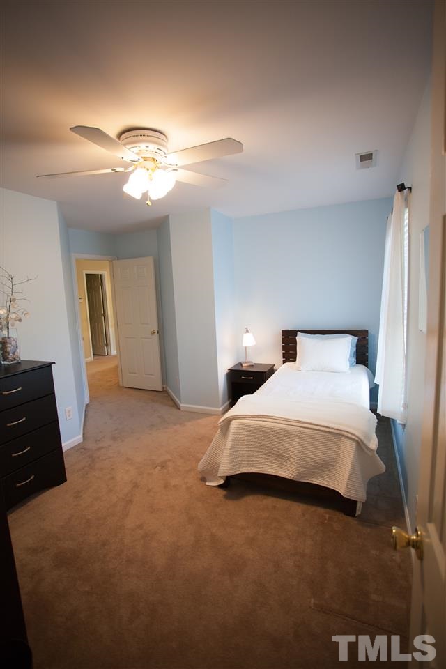 8820 Braceridge Road Raleigh, NC 27613 - Photo 17 of 22 a bedroom with a bed and a chandelier