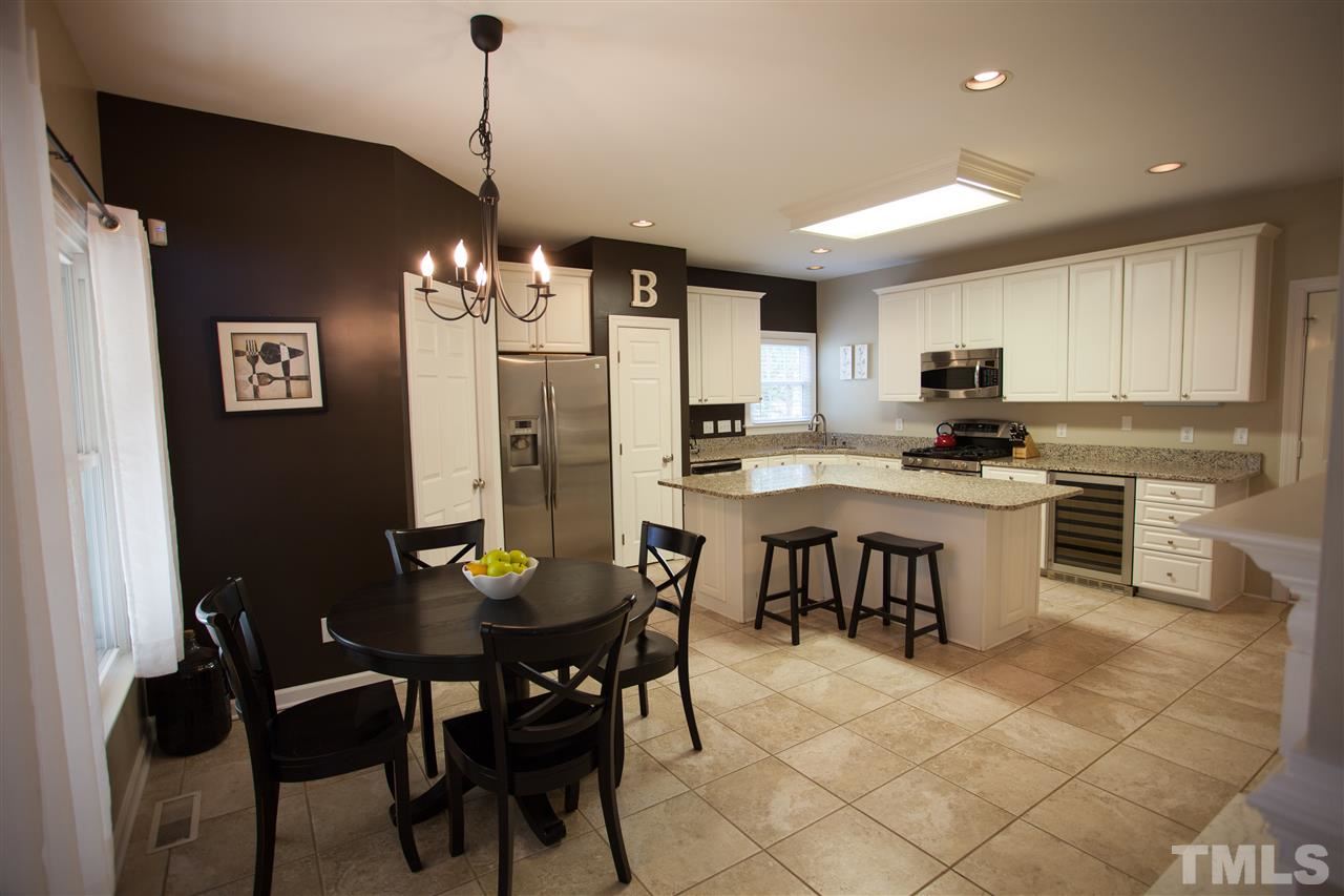 8820 Braceridge Road Raleigh, NC 27613 - Photo 8 of 22 a kitchen with a dining table chairs stainless steel appliances and cabinets