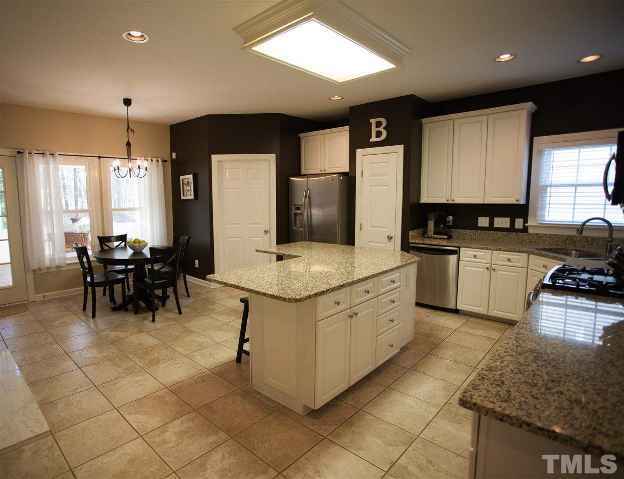 8820 Braceridge Road Raleigh, NC 27613 - Photo 9 of 22 a kitchen with stainless steel appliances granite countertop a stove a sink a oven a dining table and chairs