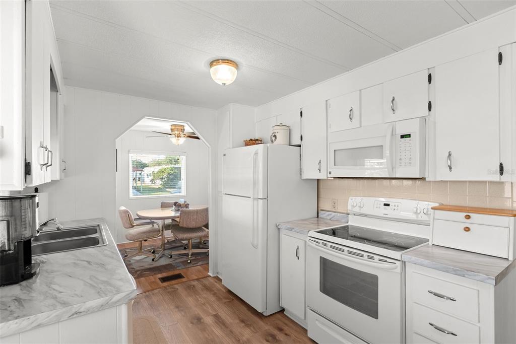 1610 Reynolds Road, Unit 98 Lakeland, FL 33801 - Photo 11 of 36 a kitchen with white cabinets and white appliances