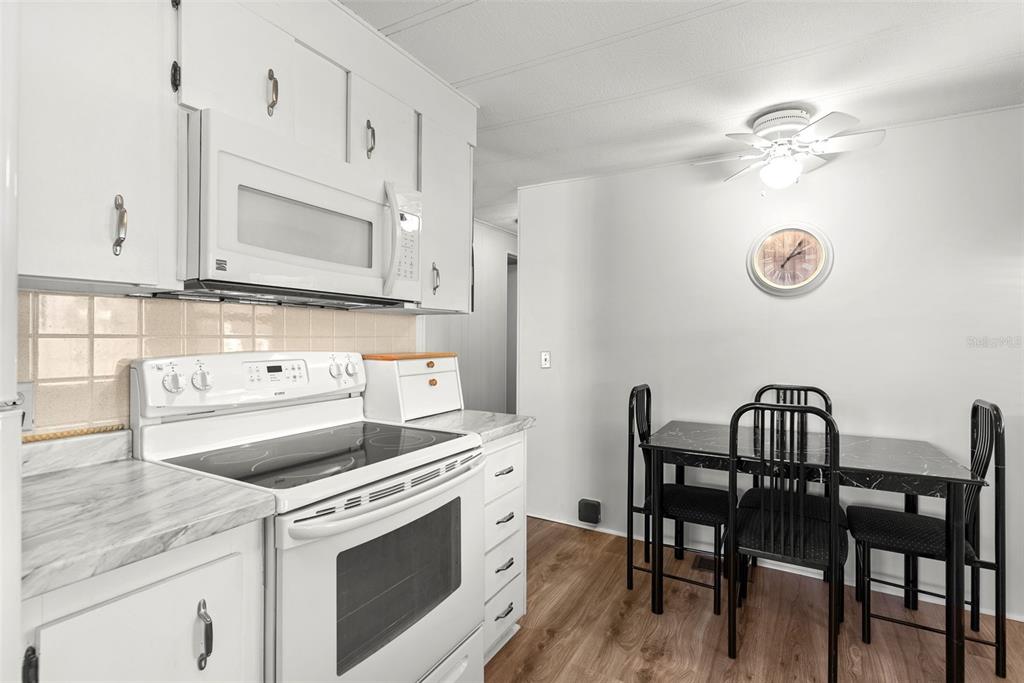 1610 Reynolds Road, Unit 98 Lakeland, FL 33801 - Photo 12 of 36 a kitchen with a table chairs and white cabinets
