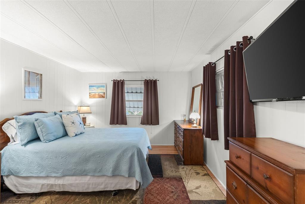 1610 Reynolds Road, Unit 98 Lakeland, FL 33801 - Photo 19 of 36 a bedroom with a bed and a dresser with mirror