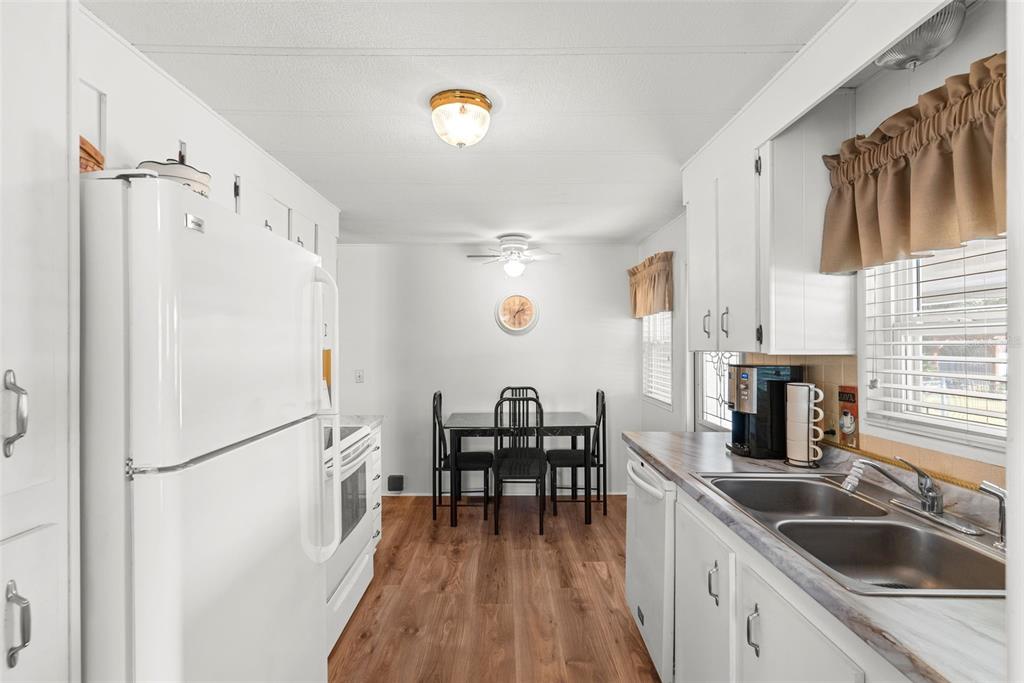 1610 Reynolds Road, Unit 98 Lakeland, FL 33801 - Photo 10 of 36 a kitchen with granite countertop a refrigerator a sink a dining table and chairs