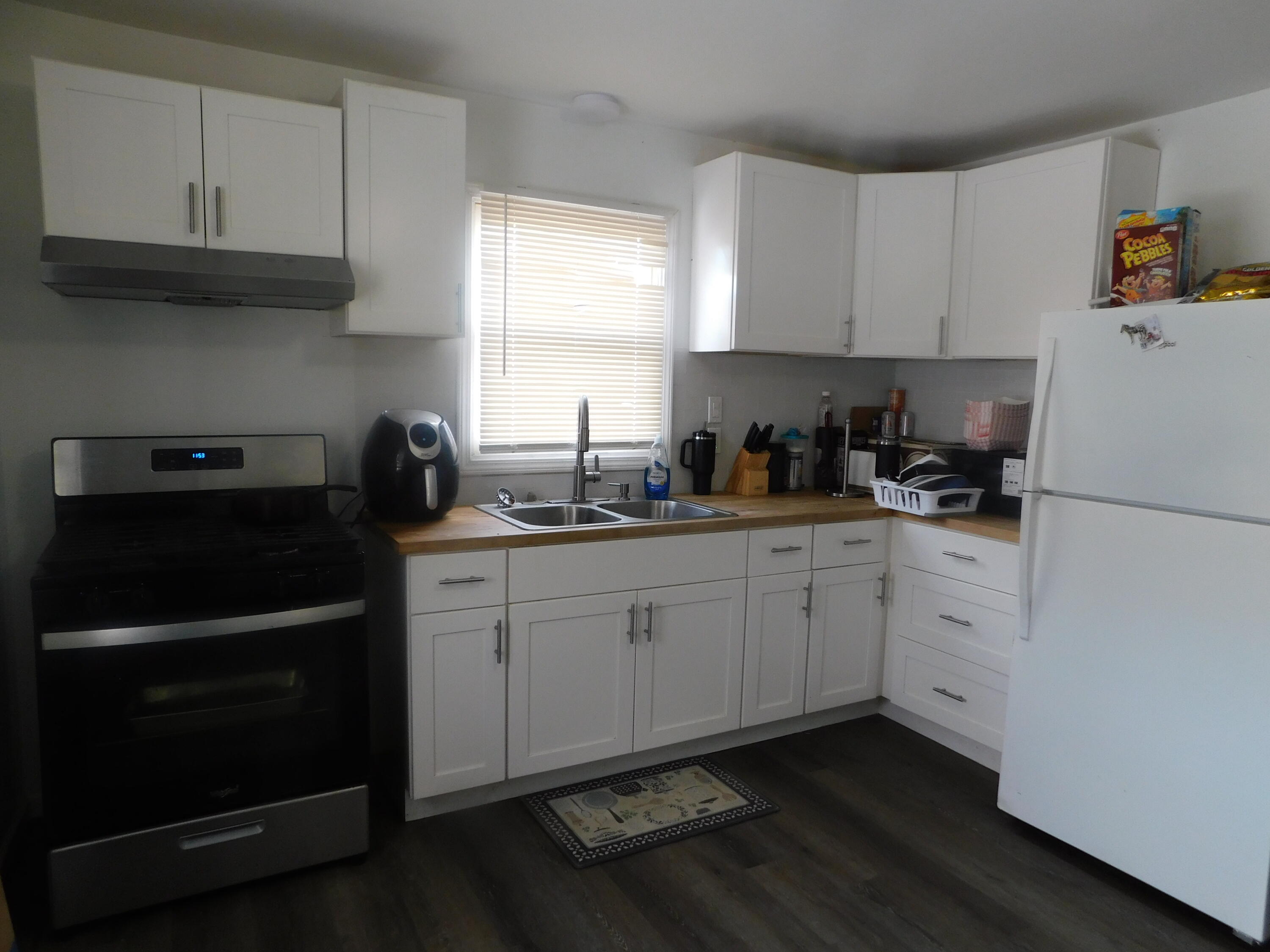 837 Spruce Street Hammond, IN 46324 - Photo 7 of 16 a kitchen with a sink dishwasher stove and white cabinets