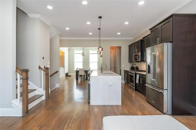 a kitchen with sink refrigerator and microwave