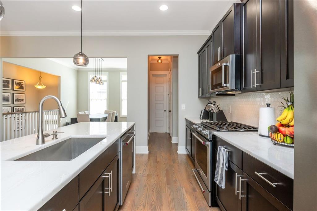2138 Shale Lane Northwest, Unit 260 Atlanta, GA 30318 - Photo 14 of 39 a kitchen with stainless steel appliances a sink stove and wooden cabinets