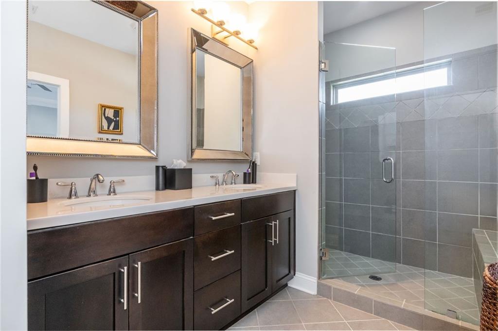 2138 Shale Lane Northwest, Unit 260 Atlanta, GA 30318 - Photo 25 of 39 a bathroom with a shower sink vanity granite and a mirror