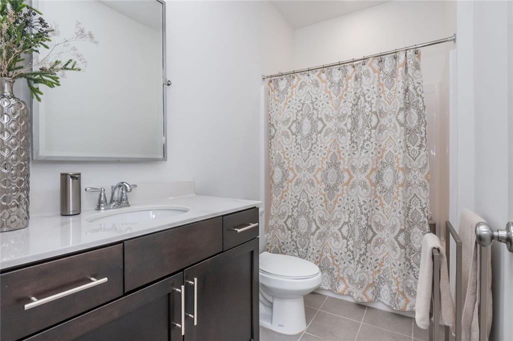 2138 Shale Lane Northwest, Unit 260 Atlanta, GA 30318 - Photo 26 of 39 a bathroom with a granite countertop sink a toilet and a mirror