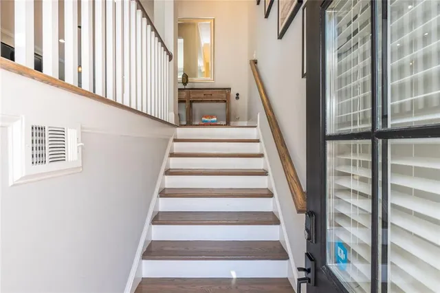 a view of staircase with lots of frames on wall and a window