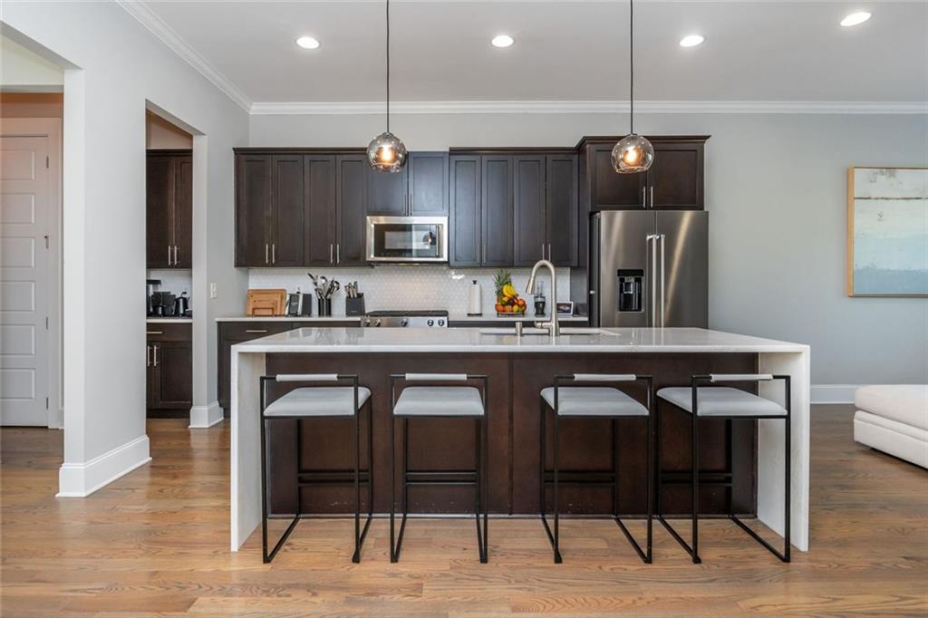 2138 Shale Lane Northwest, Unit 260 Atlanta, GA 30318 - Photo 5 of 39 a kitchen with a dining table chairs and refrigerator