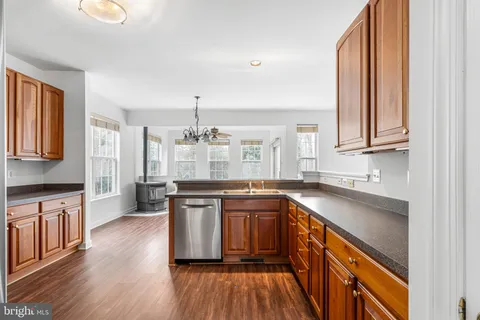 a kitchen with granite countertop wooden cabinets and stainless steel appliances