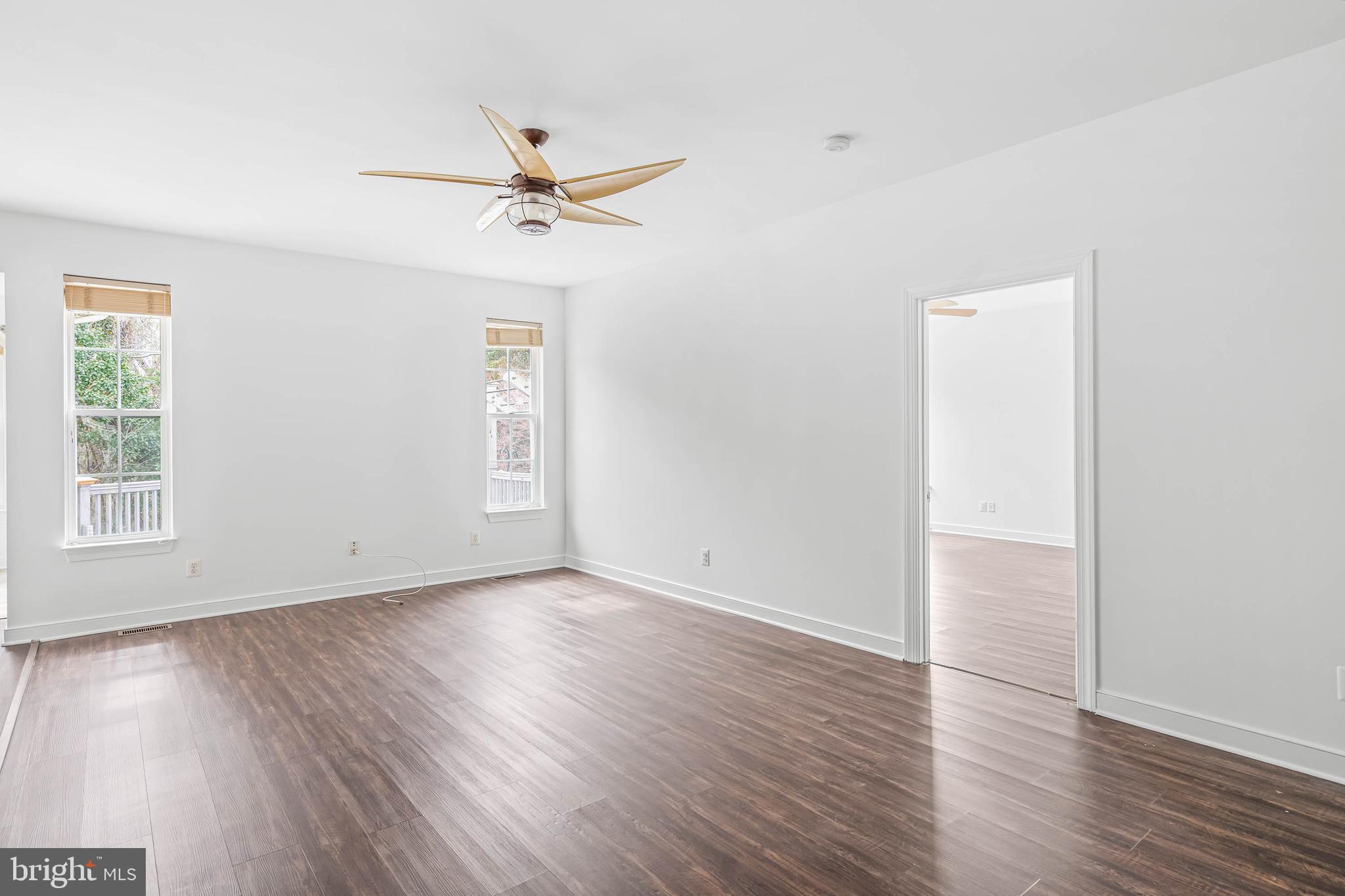 35560 Dry Brook Drive Rehoboth Beach, DE 19971 - Photo 20 of 63 an empty room with wooden floor a ceiling fan and windows