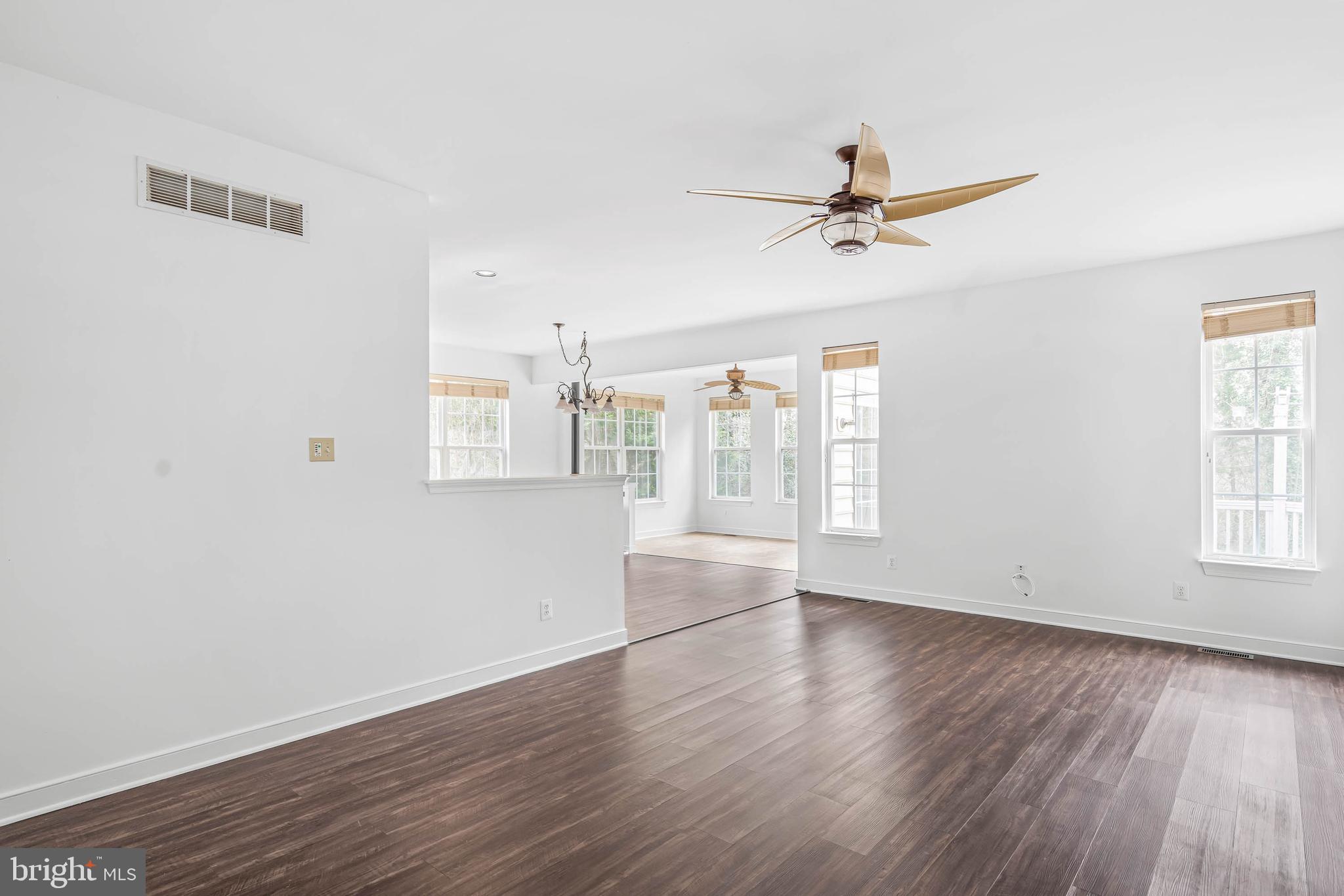 35560 Dry Brook Drive Rehoboth Beach, DE 19971 - Photo 21 of 63 an empty room with wooden floor fan and windows