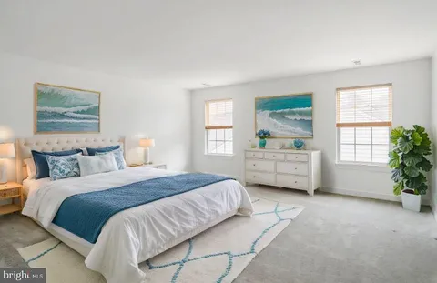 a bedroom with a bed a couch and a window