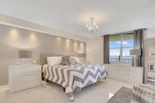 a bedroom with a large bed and a chandelier