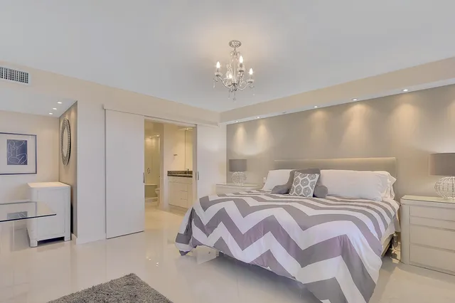 a bedroom with a bed and a chandelier