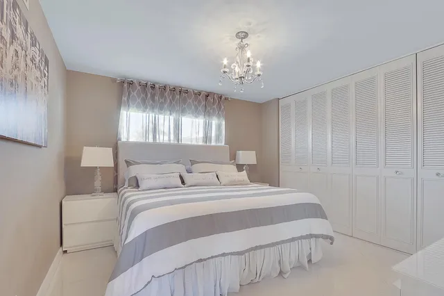 a bedroom with a large bed and a chandelier