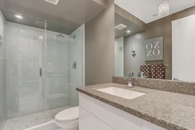 a bathroom with a granite countertop sink toilet and shower