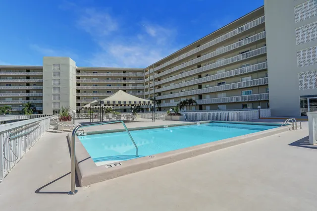 a view of a swimming pool with a chair and table in the patio