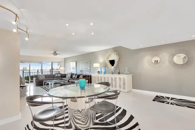 a dining room with furniture a rug and kitchen view
