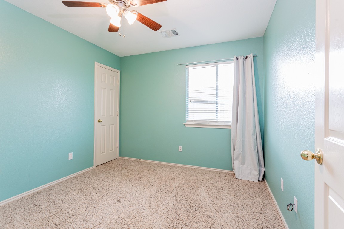 2724 Amberglow Court Round Rock, TX 78665 - Photo 14 of 18 an empty room with windows and fan