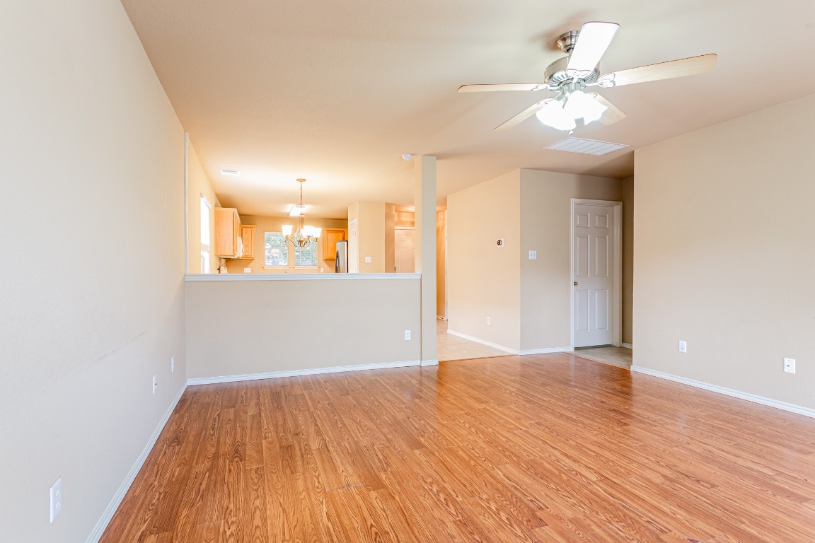 2724 Amberglow Court Round Rock, TX 78665 - Photo 7 of 18 a view of a big room with wooden floor and a chandelier fan