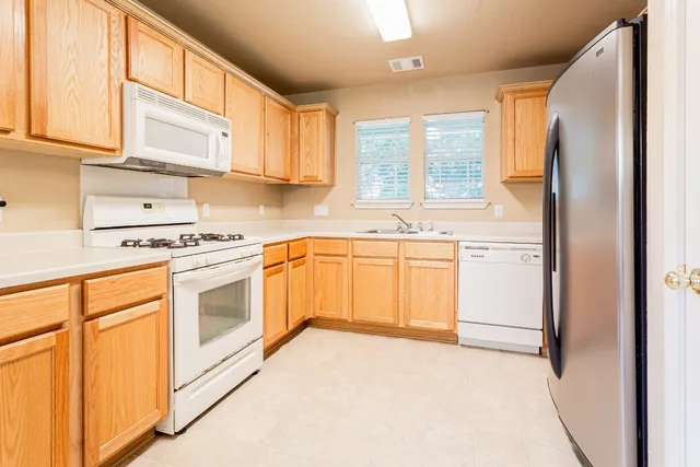 a kitchen with white cabinets and white appliances