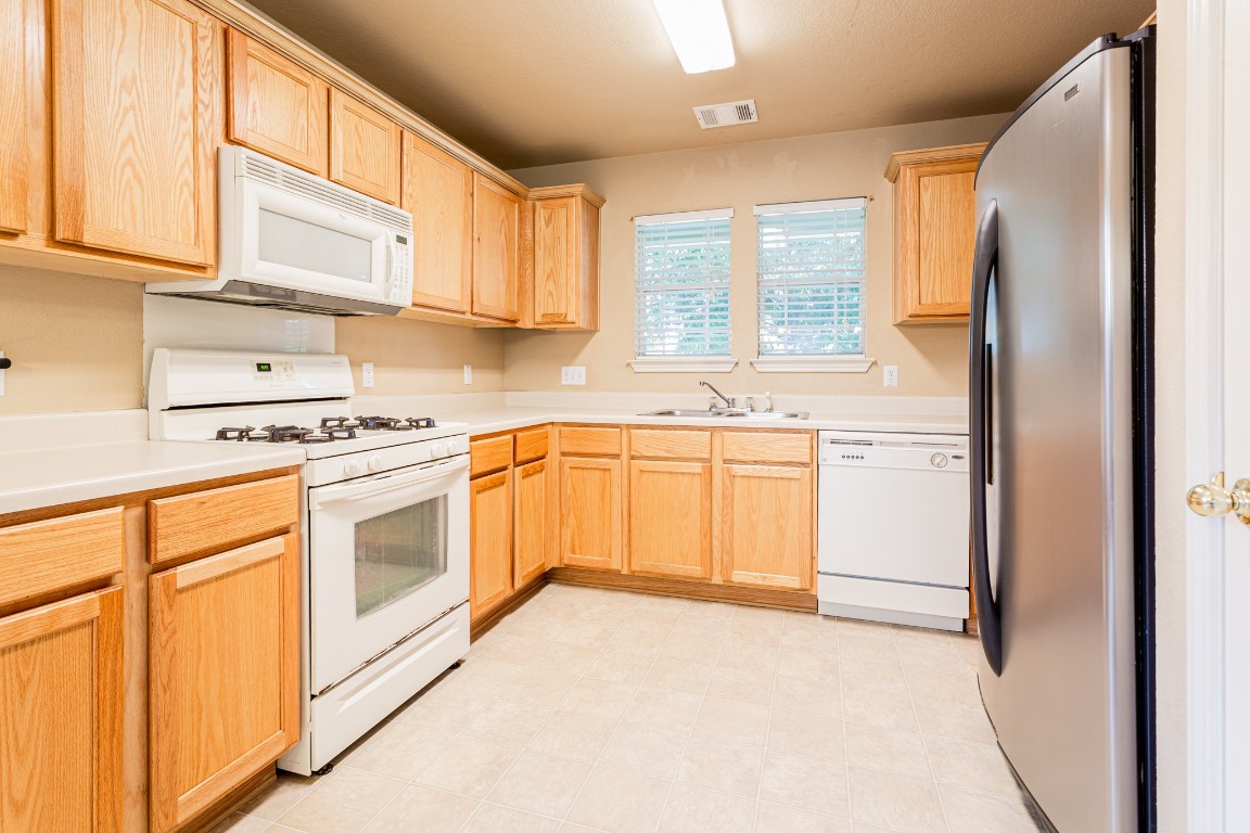 2724 Amberglow Court Round Rock, TX 78665 - Photo 8 of 18 a kitchen with white cabinets and white appliances